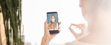 Hasta hastanın cep telefonuyla çevrimiçi video görüşmesi var. Ekranda hapları gösteriyor..