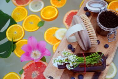 Greyfurt, limon, portakal dilimleri ve çiçeklerle rahatlatıcı bir banyo. Güzellik tedavisi. Refah kavramı