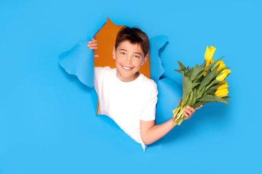 Bir buket sarı lale çiçeğiyle gülümseyen çocuk. Anneler Günü tebrik kartı. Anneler Günün kutlu olsun. Kadınlar Günü. Boşluğu kopyala.