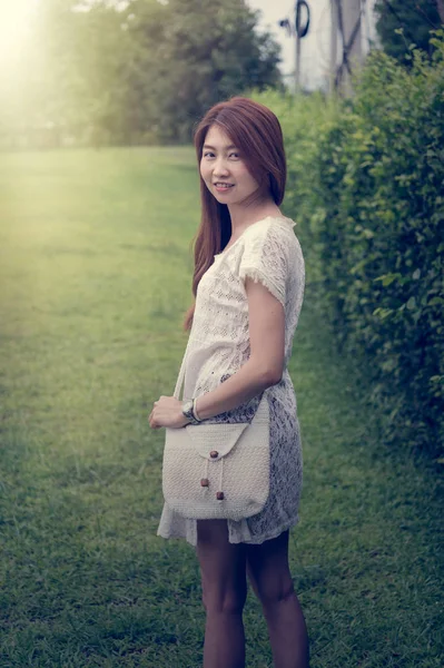Portrait of asia young girl with bag standing on park — Stock Photo, Image