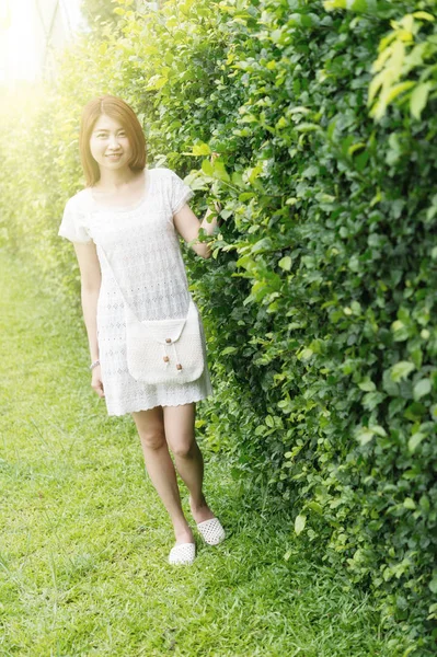 Portret młodej dziewczyny asia z torba stojący na terenie parku — Zdjęcie stockowe