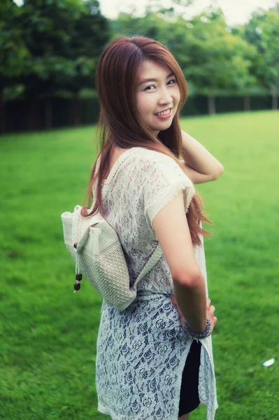 Portrait de jeune fille asiatique avec sac debout sur le parc — Photo