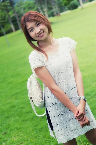 Портрет азіатської молодої дівчини з сумкою, що стоїть на парку — стокове фото