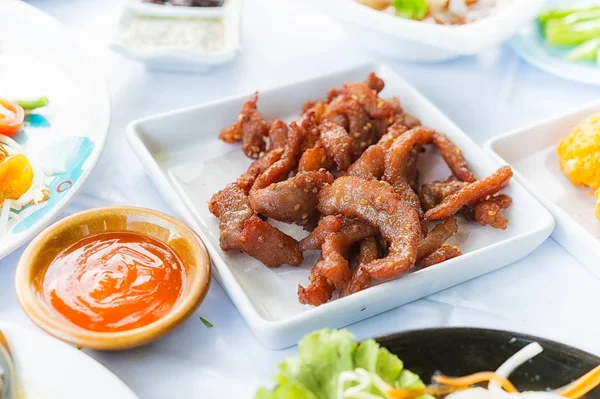 Sun dried pork fried on white dish with chilli sauce — Stock Photo, Image