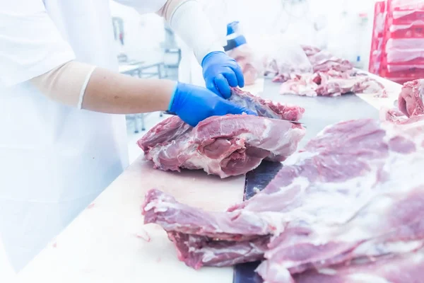 Butcher cutting the fresh meat in ham factory — Stock Photo, Image