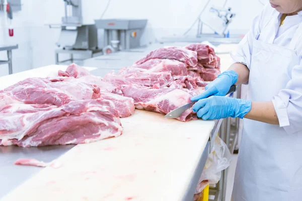 Butcher cutting the fresh meat in ham factory — Stock Photo, Image