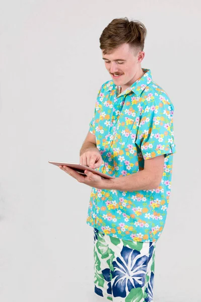 Attraente maschio in colorato utilizzando tablet su sfondo bianco — Foto Stock