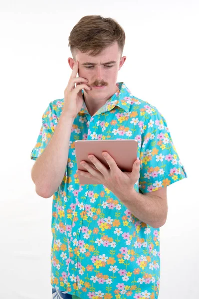 Atractivo macho en colorido usando tableta sobre fondo blanco —  Fotos de Stock