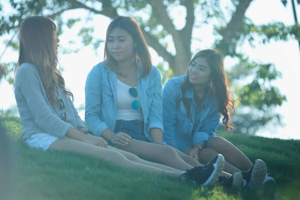 Tři Asie úsměv dívka sit na zelené trávě — Stock fotografie