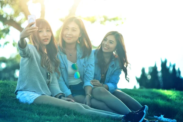 Trzy Azjatyckie Dziewczyna Selfie Smartfon Spędzaniu Wolnego Czasu Siedzieć Zielonej — Zdjęcie stockowe