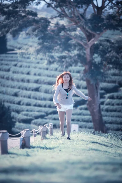 亚洲女人在茶园在绿草上运行 — 图库照片