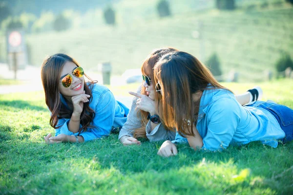 Three asia girl lying on green grass at tea farm — Stock Photo, Image