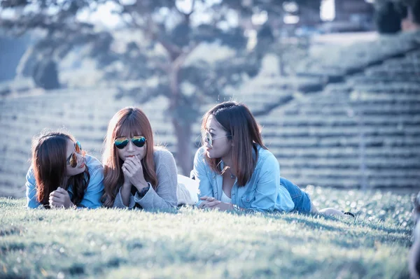 Três menina asiática deitada na grama verde na fazenda de chá — Fotografia de Stock