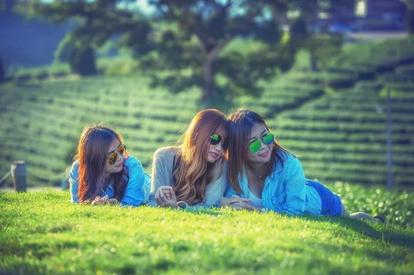 Three asia girl lying on green grass at tea farm — Stock Photo, Image