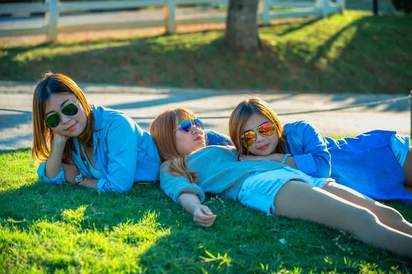 Trois asiatique fille couché sur vert herbe à thé ferme — Photo