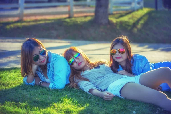 Three asia girl lying on green grass at tea farm — Stock Photo, Image