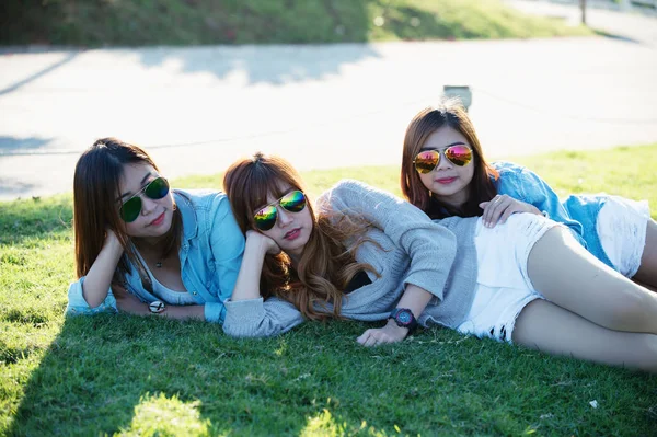 Three asia girl lying on green grass at tea farm — Stock Photo, Image