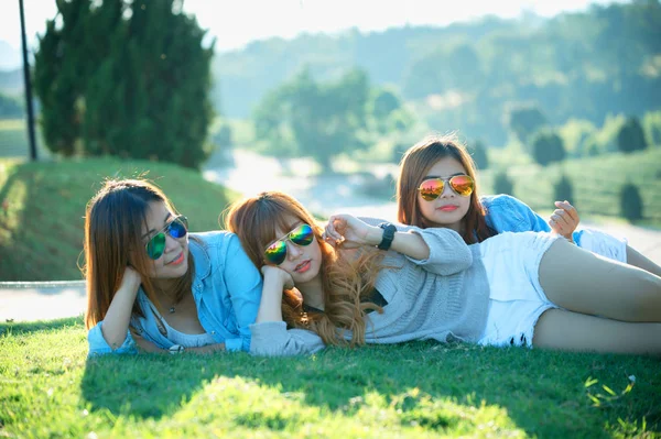 Three asia girl lying on green grass at tea farm — Stock Photo, Image