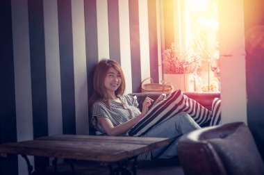 cep telefonu kullanarak ve kanepe evinde yatarken Asya kadın