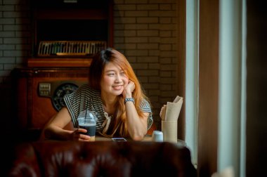 Asya güzel kadın kahve dükkanında rahatla