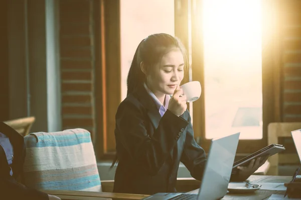 Joven empresaria bebiendo café caliente durante la reunión — Foto de Stock