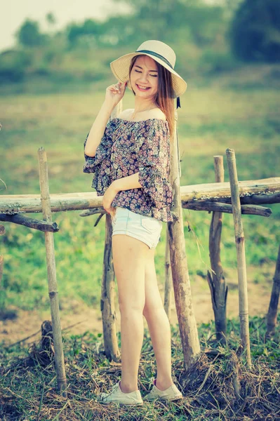 asia woman in Off  Shoulder shirt and short jeans with hat standing on nature