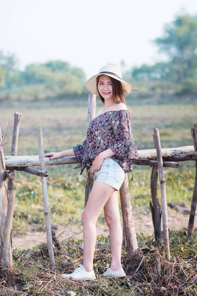 asia woman in Off  Shoulder shirt and short jeans with hat standing on nature