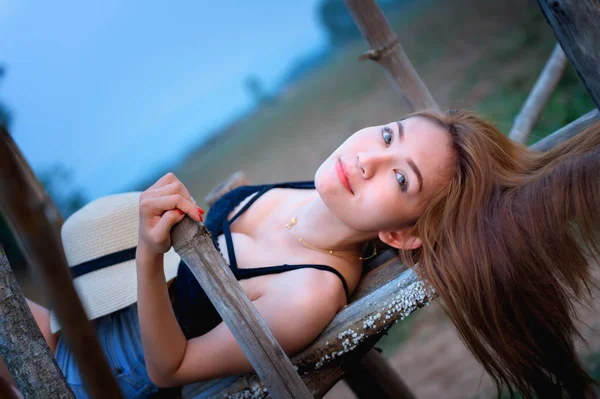 Азиатка в летней моде лежит на бамбуковом мосту — стоковое фото