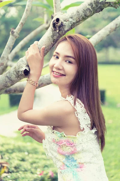 Asia hermosa chica de pie cerca del árbol en el parque — Foto de Stock