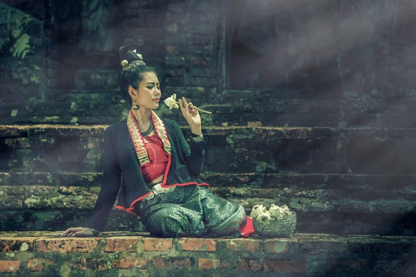 ancient Thai beautiful women in vintage dress thai style sitting, vintage effect