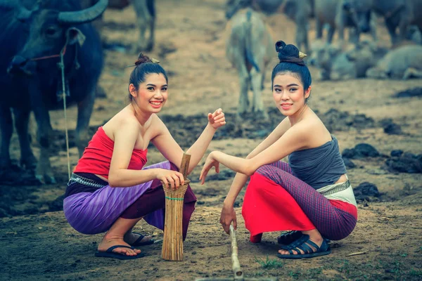 Buffalo çiftliğinde ile ulusal Kostüm giymiş iki Asyalı kadınlar — Stok fotoğraf