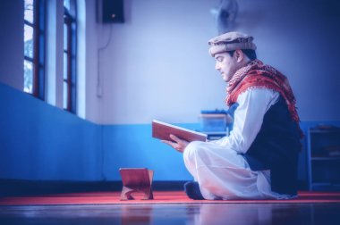 Camide Kur 'an okuyan dindar Müslüman adam.