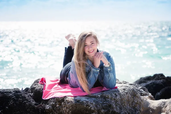 Молода жінка лежить на камені на пляжі Багами — стокове фото