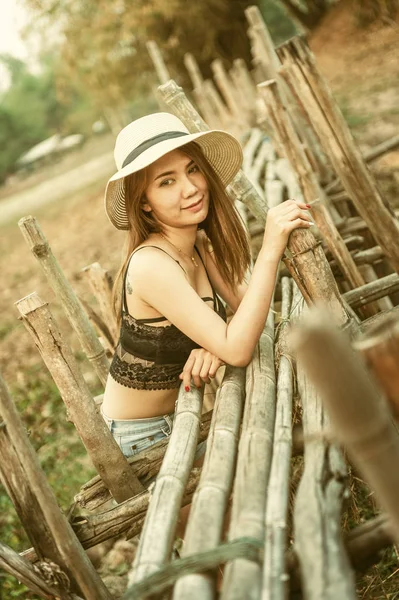 アジアセクシー女性で夏ファッションで黒ブラジャー ジーンズと帽子ポージングとともに古い竹の橋 — ストック写真