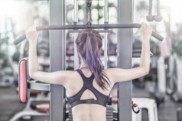 Asyalı kadın spor salonunda egzersiz yapıyor.