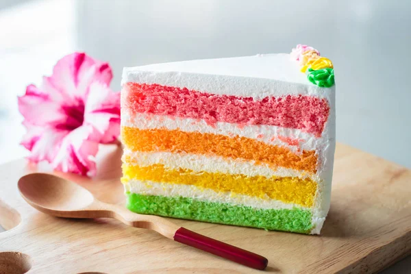 Delicious rainbow cake on wood plate. — Stock Photo, Image