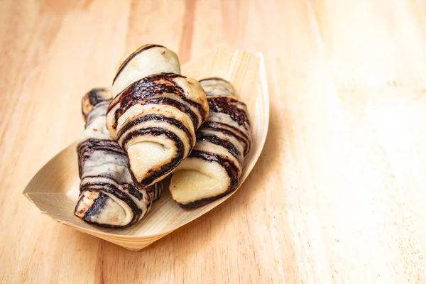 Chutné čerstvé croissanty na dřevěné pozadí. — Stock fotografie