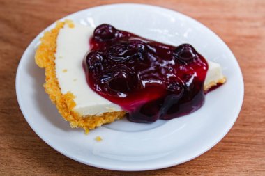 Yaban mersinli cheesecake ahşap plaka üzerinde.