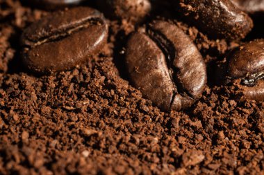 Kavrulmuş espresso kahve çekirdekleri ve toz yakın plan.
