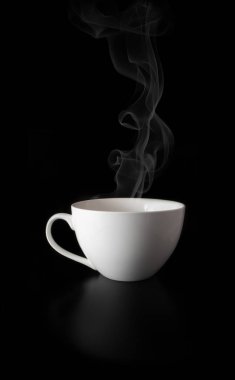 Siyah arka planda buharlı beyaz porselen bardak.