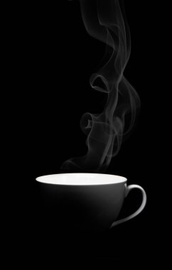 Siyah arka planda buharlı beyaz porselen bardak.