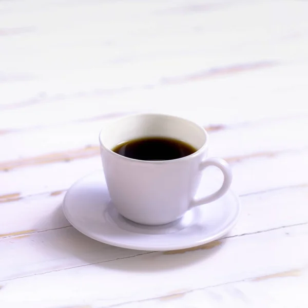 white coffee cup on a white wooden table