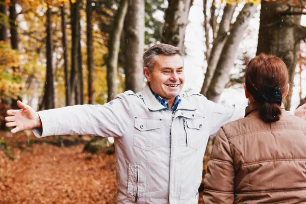 Senior para cieszyć się jesienią w lesie. — Zdjęcie stockowe