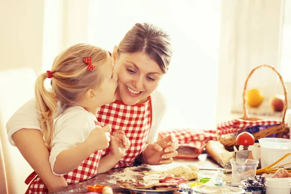 Meisje kuste haar moeder terwijl voorbereiding Gingerbread koekjes — Stockfoto