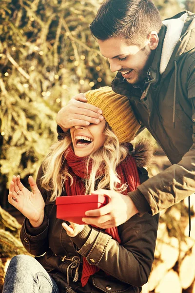 Молодий чоловік дивує дівчину подарунком . — стокове фото