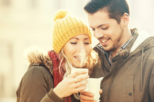 Pareja feliz tomando bebidas calientes al aire libre. Día de invierno . —  Fotos de Stock