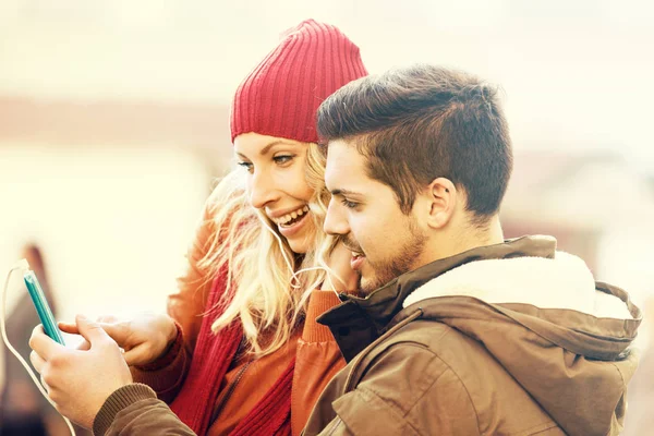 Pareja feliz escuchando música al aire libre — Foto de Stock