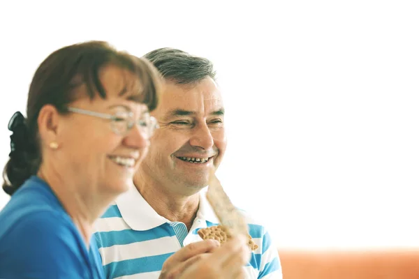 Casal sênior comer biscoitos — Fotografia de Stock