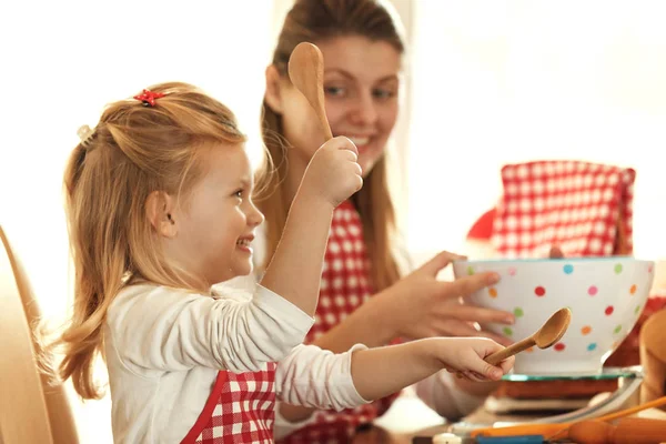 Moeder en dochter meten ingrediënten te maken deeg — Stockfoto