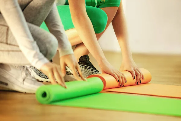 Rollen Yoga matten na klasse. Vrouw in de sportschool. — Stockfoto